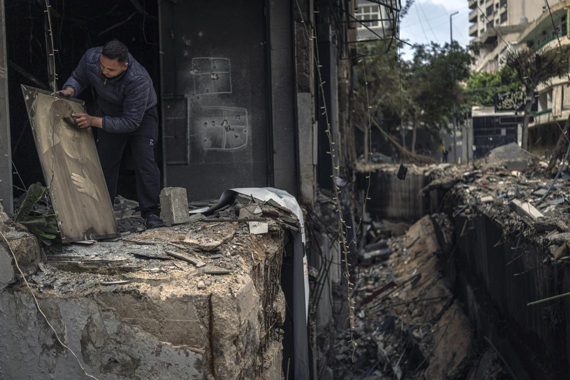 A man cleans off a portrait of the slain Hezbollah leader Hassan Nasrallah while clearing debris from a building destroyed in an Israeli airstrike in Dahiyeh, the suburb south of Beirut, Lebanon, on Monday, April 20, 2026. Joseph Aoun, the Lebanese president, said that he had appointed Simon Karam, a former ambassador to the United States, to lead talks with Israel aimed at ending the war and achieving a complete Israeli withdrawal from southern Lebanon. (Diego Ibarra Sánchez/The New York Times)