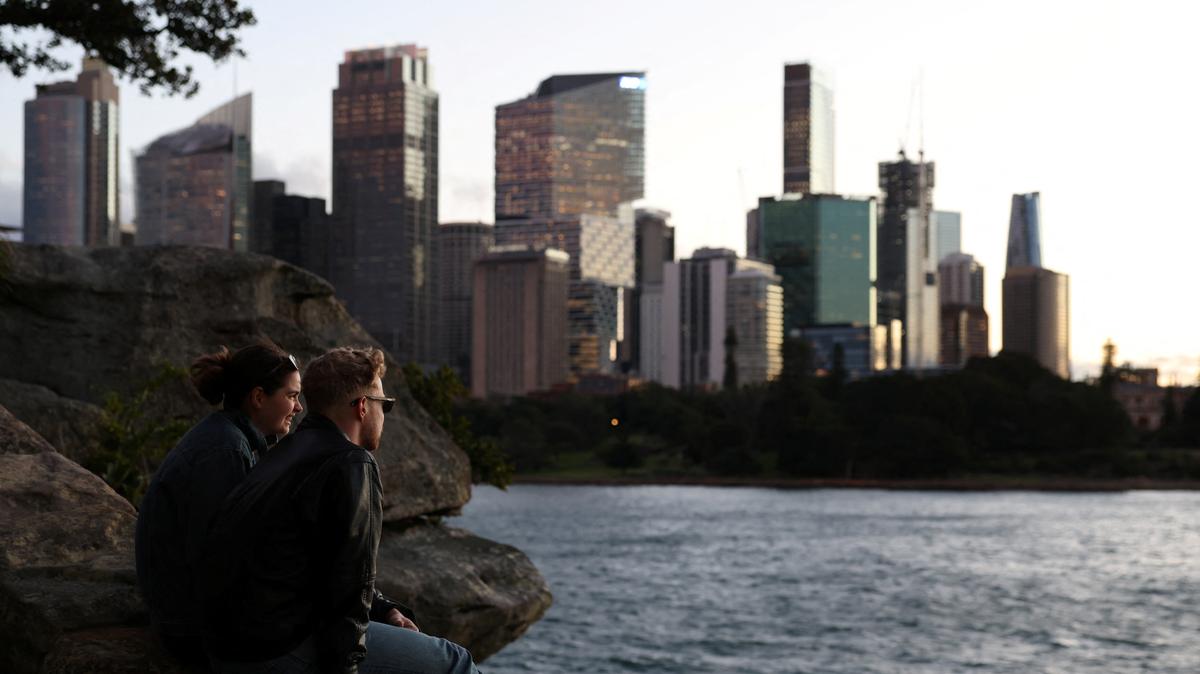 People sit and watch the sunset over the Central Business District (CBD) skyline in Sydney, Australia, July 10, 2025. REUTERS/Hollie Adams