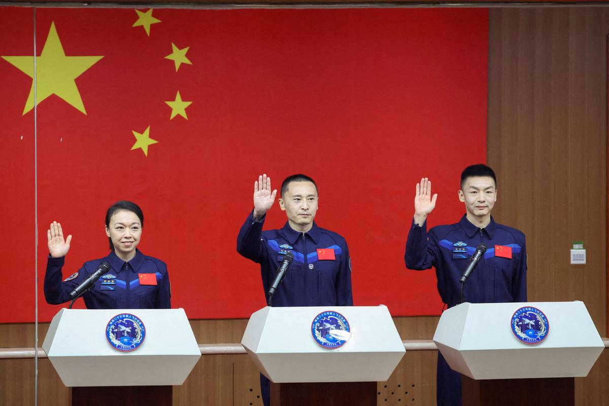 Astronauts Zhu Yangzhu, Zhang Zhiyuan, and Lai Ka-ying, who is the first astronaut from Hong Kong, gesture as they attend a press conference before the Shenzhou-23 spaceflight mission to China's Tiangong space station, at Jiuquan Satellite Launch Center, near Jiuquan, Gansu province, China, May 23, 2026. REUTERS/Maxim Shemetov