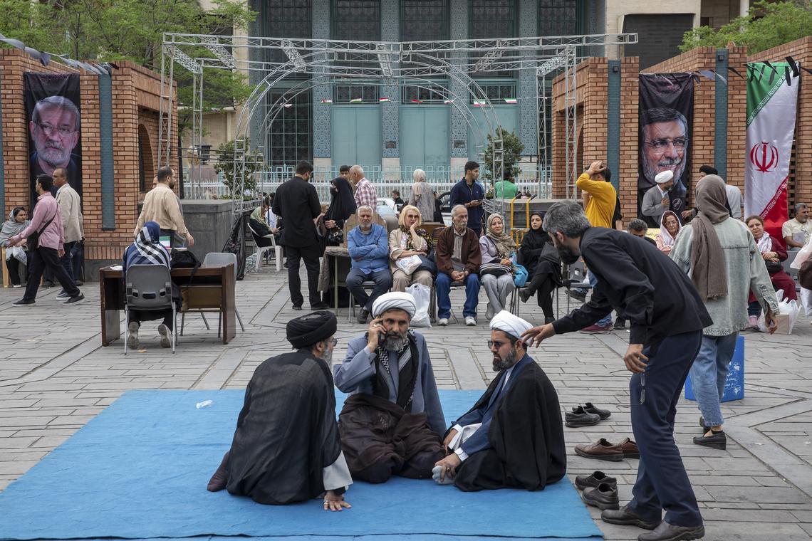 Clerics and others rest at the Grand Bazaar near images of Iranian Revolutionary Guard commanders and officials killed in airstrikes in Tehran, on Monday, April 20, 2026. Despite sending mixed signals in recent days, both the United States and Iran gave clearer indications on Monday that they were planning to send negotiators to peace talks in Pakistan this week. (Arash Khamooshi/The New York Times)