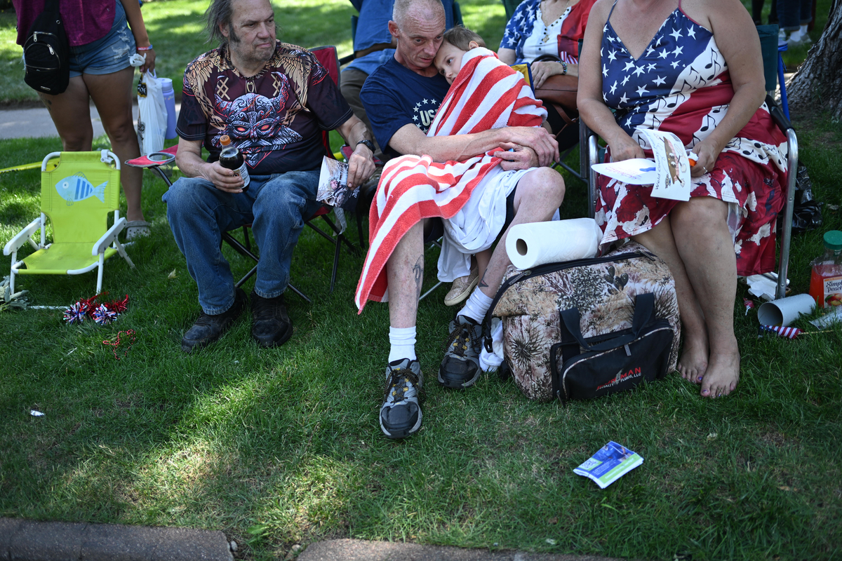 A young attendee is comforted after being drenched by a fire truck during the Greeley Stampede's Independence Day parade in Greeley, Colo., July 4, 2026. America celebrates the 250th anniversary of its independence today, with people from one end of the country to the other marking the milestone with fireworks, parades and concerts. (Mark Makela/The New York Times)