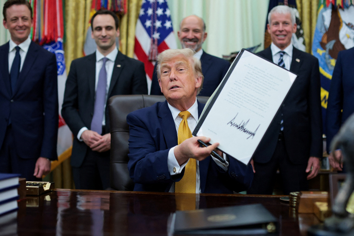 U.S. President Donald Trump shows a signed executive order regarding Quantum Computing, in the Oval Office at the White House in Washington, D.C., U.S., June 22, 2026. REUTERS/Jonathan Ernst