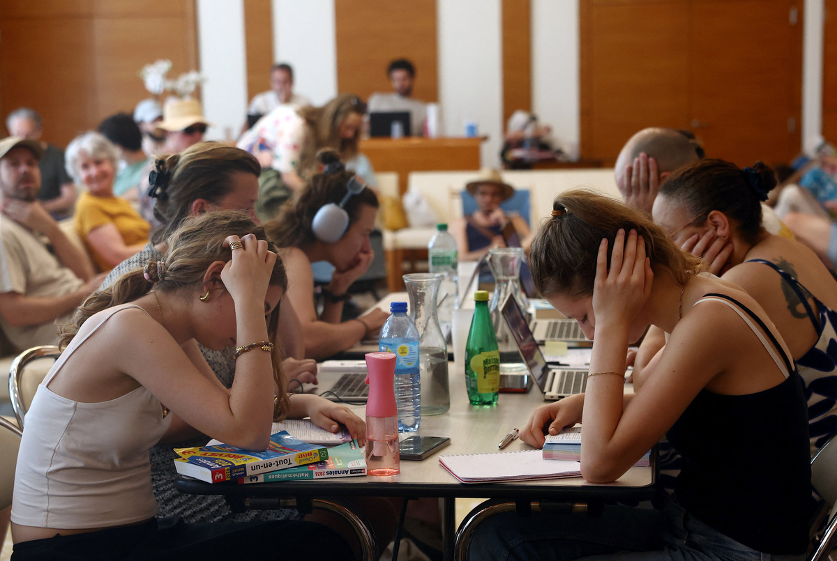 Middle school students work to prepare the "brevet des colleges" (middle school diploma) inside an air-conditioned room open to the public inside the 17th district city hall as temperatures rise in Paris, during a heatwave affecting a majority of the country, in France, June 25, 2026. REUTERS/Alice Sacco