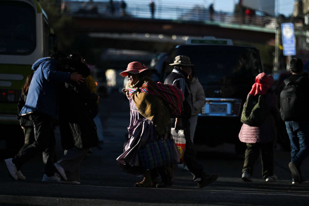 People walk through the city streets as Bolivia's crisis begins to ease after lawmakers backed the state of emergency, in El Alto, Bolivia, June 21, 2026. REUTERS/Claudia Morales
