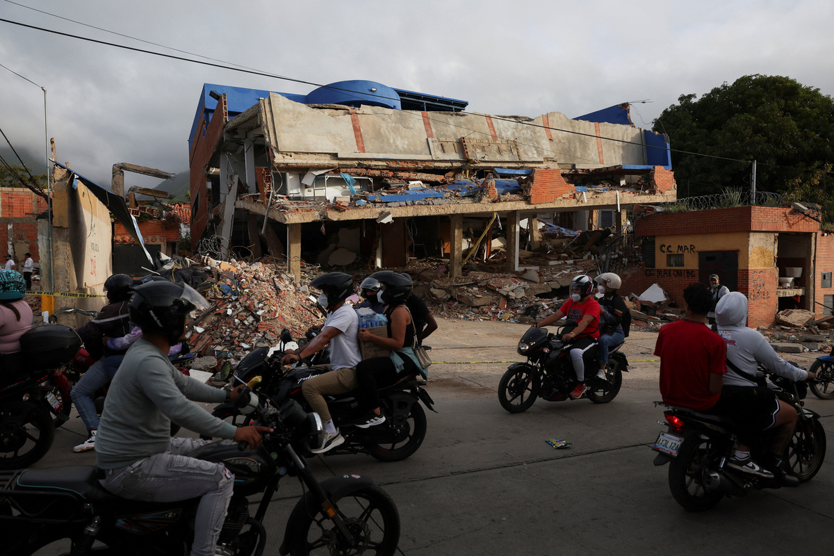 Commuters pass by a damaged building in the aftermath of the June 24 earthquakes, in La Guaira, Venezuela, July 4, 2026. REUTERS/Pablo Sanhueza