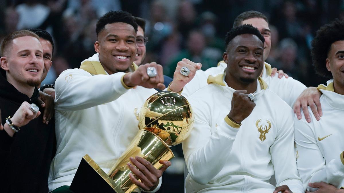 Milwaukee Bucks’ Giannis Antetokounmpo, second from left, and Thanasis Antetokounmpo show off their championship rings before the team’s NBA basketball game against the Brooklyn Nets, Tuesday, Oct. 19, 2021, in Milwaukee. (AP Photo/Morry Gash)