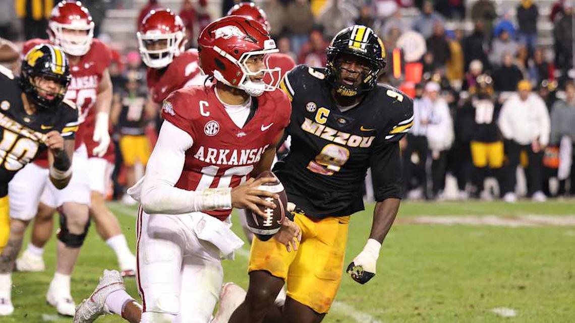  Nov 29, 2025; Fayetteville, Arkansas, USA; Arkansas Razorbacks quarterback Taylen Green (10) rushes against Missouri Tigers defensive end Zion Young (9) during the fourth quarter at Donald W. Reynolds Razorback Stadium. Missouri won 31-17. Mandatory Credit: Nelson Chenault-Imagn Images | Nelson Chenault-Imagn Images 