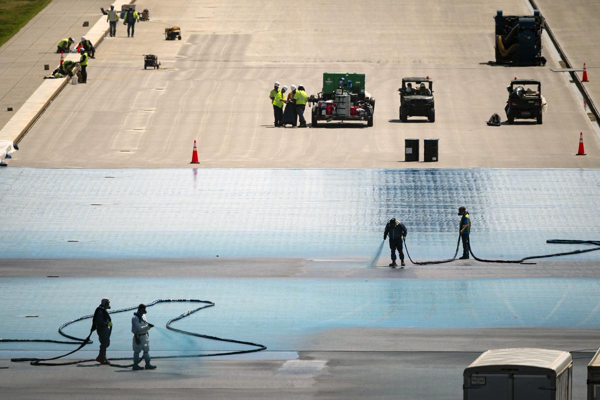 Workers apply blue paint to the bottom of the Lincoln Memorial Reflecting Pool in Washington on Saturday, May 9, 2026. "Every day that the resurfacing continues, the historic character of the Reflecting Pool is being further and fundamentally altered," a lawsuit filed Monday, May 11,2026, says. (Al Drago/The New York Times)