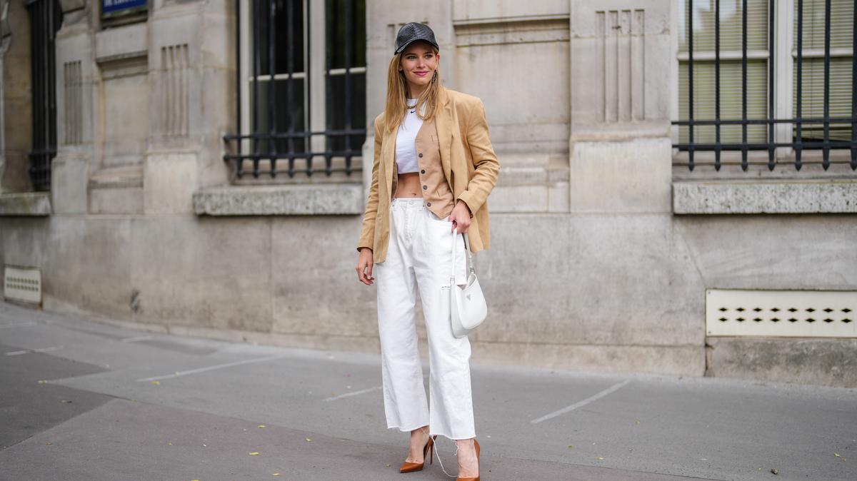 PARIS, FRANCE - MAY 16: Natalia Verza @mascarada.paris wears, a black leather cap, a beige linen oversized blazer jacket from Aeron, a white cropped t-shirt, white ripped denim jeans pants, a white Prada Cleo bag, high heels pointed pumps shoes from Louboutin, on May 16, 2021 in Paris, France. (Photo by Edward Berthelot/Getty Images)