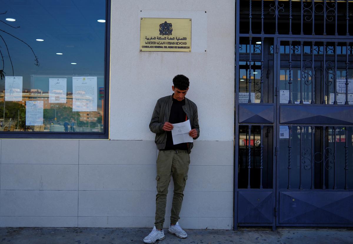 Moroccan migrant Abdelmoujoud Erra, 27, holds his criminal certificate outside Moroccan Consulate General before travelling to Valladolid to obtain a vulnerability certificate to regularise his migration status, in Almeria Spain, April 22, 2026. Erra says “Without documents, it’s five euros an hour. With them, maybe seven or eight,” REUTERS/Nacho Doce
