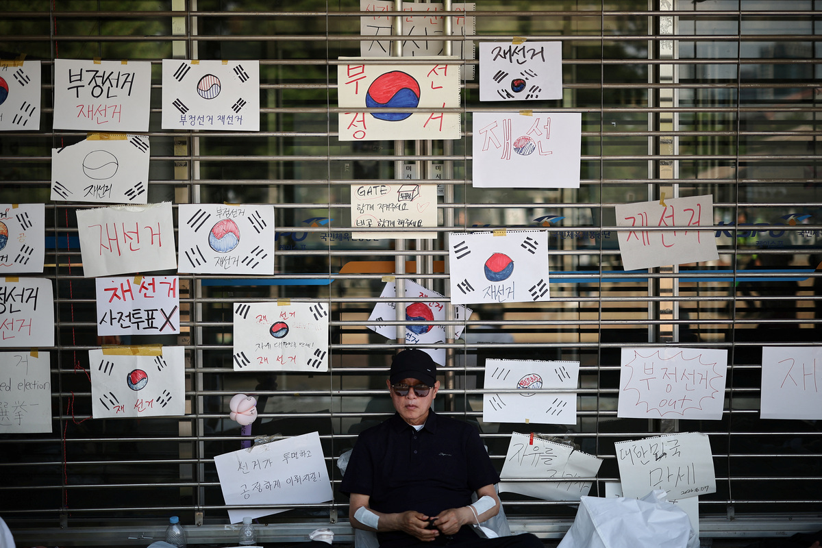 A man sits outside a vote-counting centre during a protest to demand a rerun of the local election, amid a ballot paper shortage that disrupted voting, in Seoul, South Korea, June 10, 2026. REUTERS/Kim Hong-Ji