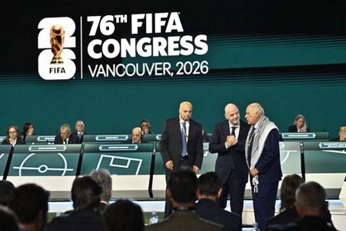 Soccer Football - 76th FIFA Congress - Vancouver Convention Centre, Vancouver, Canada - April 30, 2026  FIFA President Gianni Infantino shakes hands with Jibril Rajoub, President of the Palestine Football association as Moshe Zuares, President of the Israeli football federation looks on during the congress REUTERS/Jennifer Gauthier
