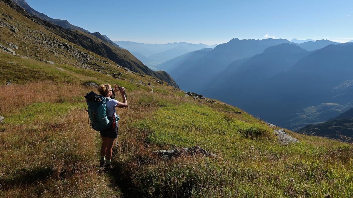 NEUSTIFT IM STUBAITAL, AUSTRIA - AUGUST 25: An alpine hiker takes a photo with her smartphone along the challenging Stubaier Höhenweg hiking trail between the Innsbrucker Hütte and Bremer Hütte mountain huts on August 25, 2022 near Neustift im Stubaital, Austria. The Stubaier Höhenweg, located in the Stubai Alps (Stubaier Alpen) mountain range in Tyrol, is among the most popular hiking trails in Austria. (Photo by Sean Gallup/Getty Images)