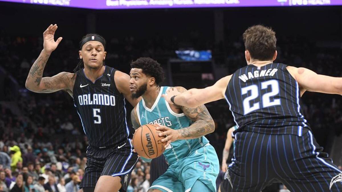  Mar 25, 2025; Charlotte, North Carolina, USA; Charlotte Hornets forward Miles Bridges (0) drives past Orlando Magic forward Paolo Banchero (5) and forward Franz Wagner (22) during the second half at the Spectrum Center. Mandatory Credit: Sam Sharpe-Imagn Images | Sam Sharpe-Imagn Images 