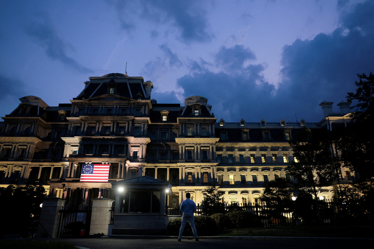 A journalist stands outside the White House with the Eisenhower Executive Office Building in the background ahead of U.S. President Donald Trump's address to the nation, in Washington, D.C., U.S., July 16, 2026. REUTERS/Kylie Cooper