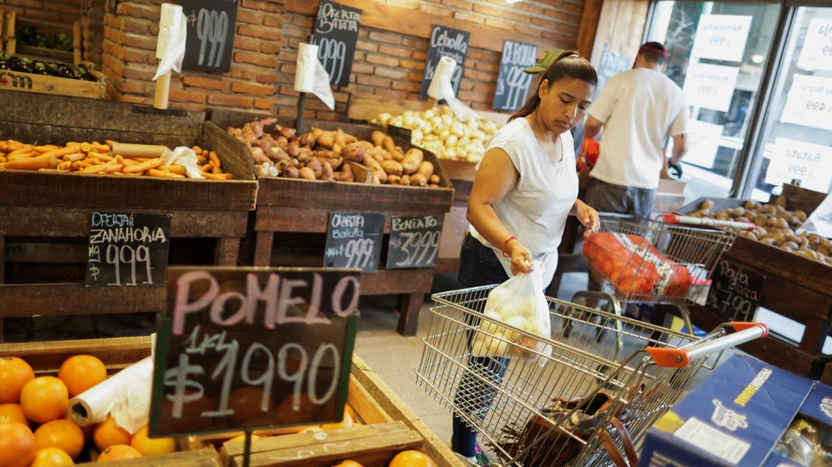 A woman puts a bag in a shopping cart at a greengrocer's in Buenos Aires, Argentina December 11, 2025. REUTERS/Francisco Loureiro