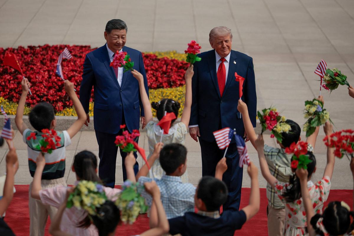 U.S. President Donald Trump is welcomed by children during a ceremony with Chinese President Xi Jinping at the Great Hall of the People in Beijing, China, May 14, 2026. REUTERS/Evan Vucci