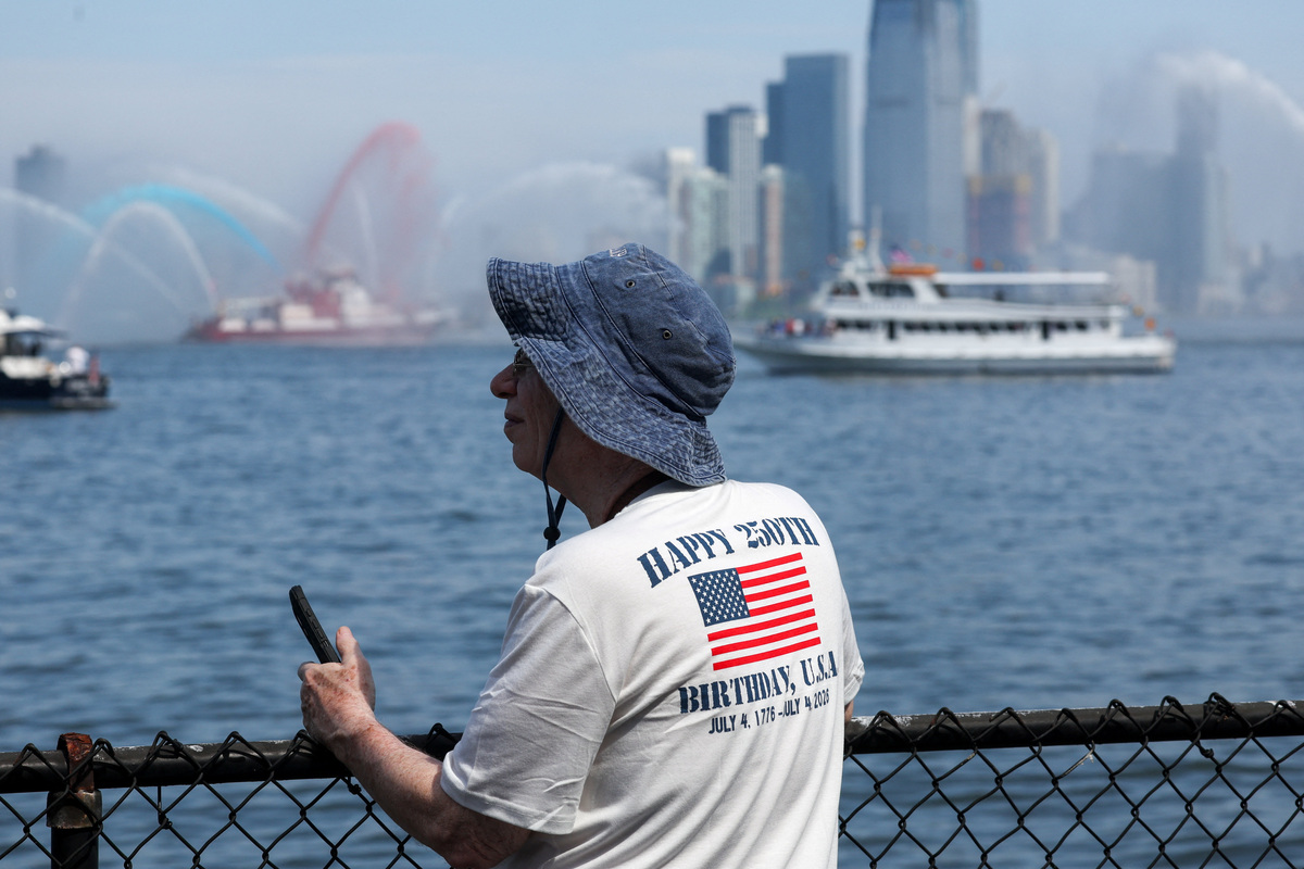 A person watches the Sail 250 parade of ships amid celebrations for the United States' 250th anniversary on Independence Day in New York City, U.S., July 4, 2026. REUTERS/Shannon Stapleton