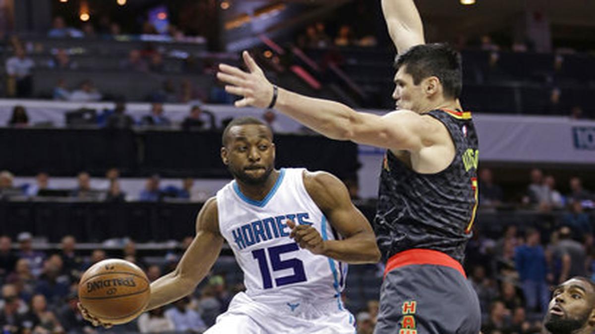 Charlotte Hornets' Kemba Walker (15) drives past Atlanta Hawks' Ersan Ilyasova 