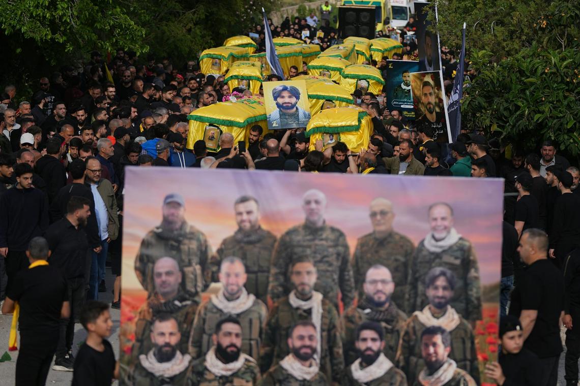  Mourners carry the coffins of Hezbollah fighters killed in the war between Hezbollah and Israel during a funeral in Kfar Sir, Lebanon, on April 21, 2026. AP Photo/Hassan Ammar 