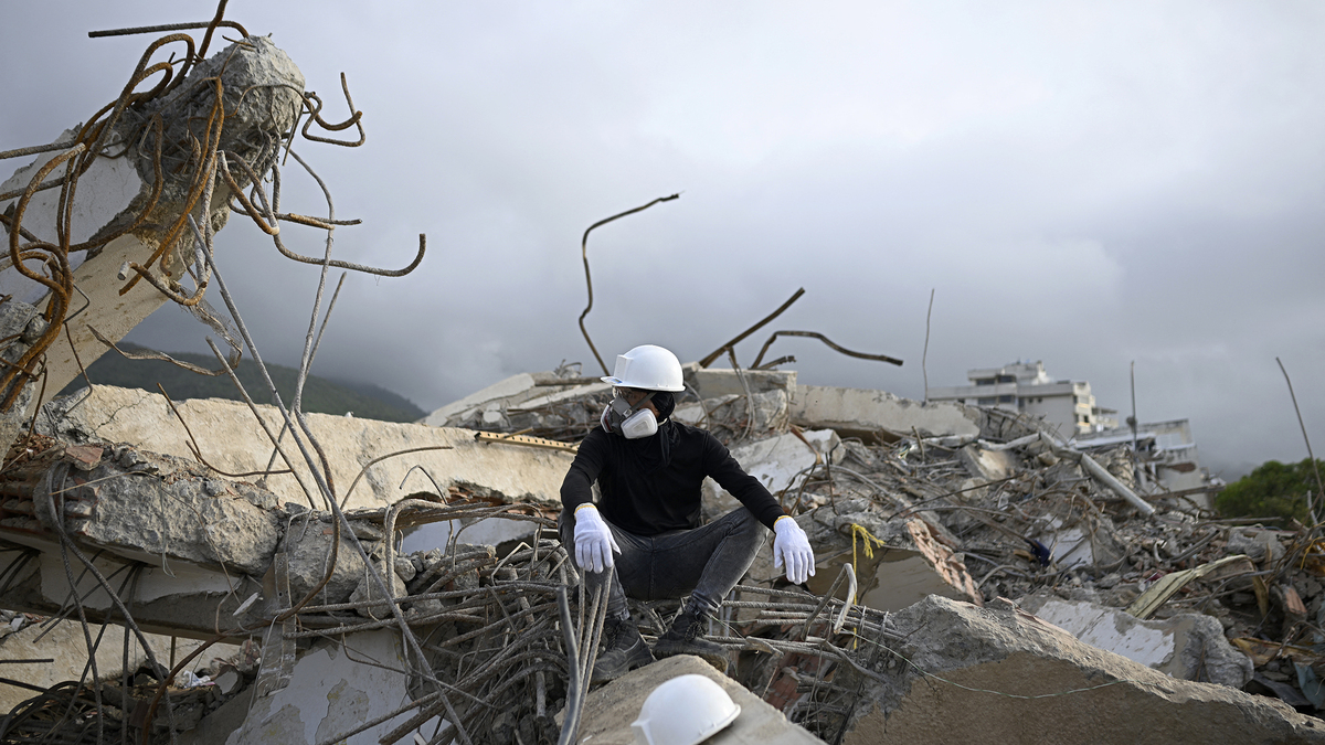 A rescue worker wearing protective gear pauses atop the rubble of a collapsed building in Los Corales, La Guaira state, Venezuela, on July 13, 2026, following twin earthquakes that struck the region. The death toll from the twin earthquakes that struck Venezuela nearly three weeks ago has surpassed 4,500, while the number of injured remains at about 17,000, according to the latest government report released on July 13. (Federico Parra/AFP via Getty Images/TNS)