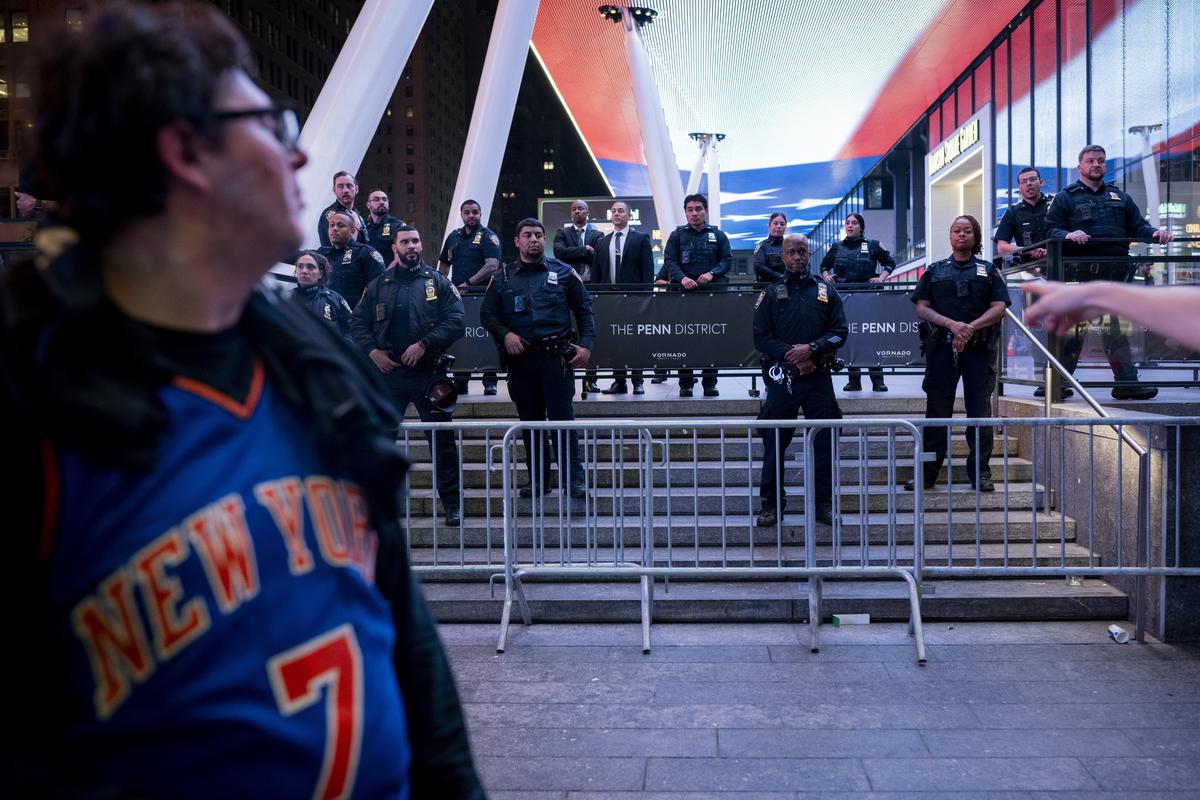 Police look on as jubilant Knicks fans celebrate outside Madison Square Garden in New York after their team swept the Cleveland Cavaliers in the Eastern Conference Finals to advance to the NBA Finals for the first time since 1999 on Monday night, May 25, 2026. Thousands of fans blocked traffic outside Madison Square Garden, even though the game was in Ohio and the outdoor watch parties at the Garden had been suspended because of rowdy fans. (Vincent Alban/The New York Times)