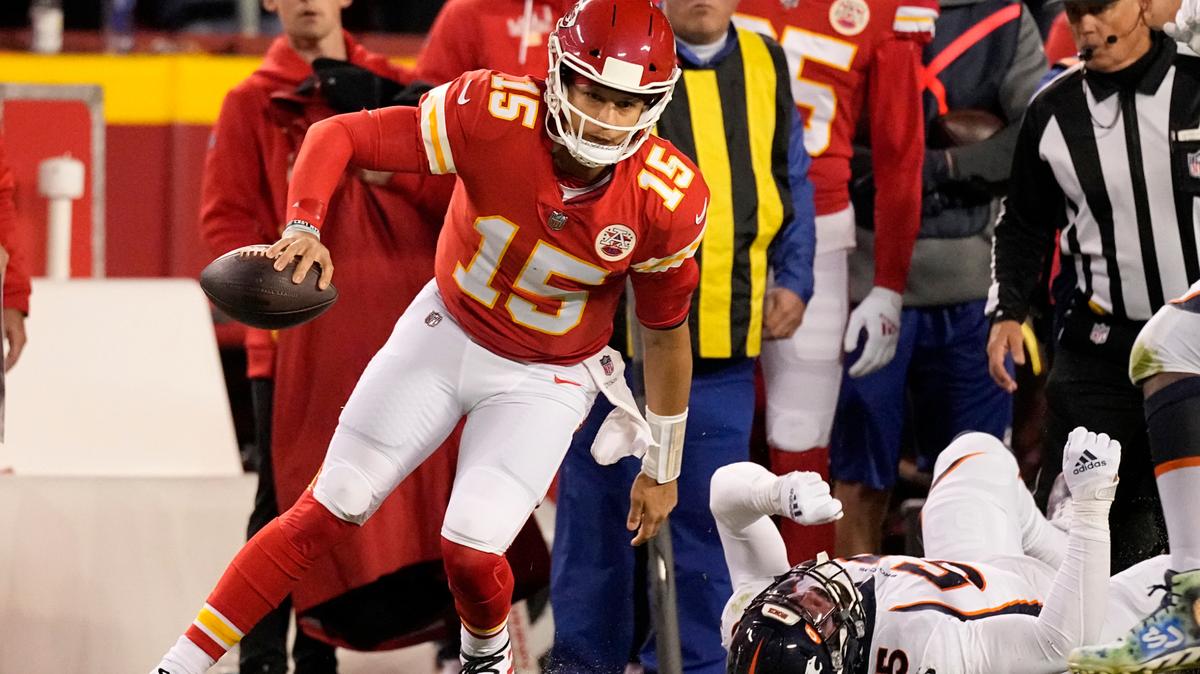 Kansas City Chiefs quarterback Patrick Mahomes (15) runs past Denver Broncos linebacker Bradley Chubb (55) during the first half of an NFL football game Sunday, Dec. 5, 2021, in Kansas City, Mo. (AP Photo/Charlie Riedel)