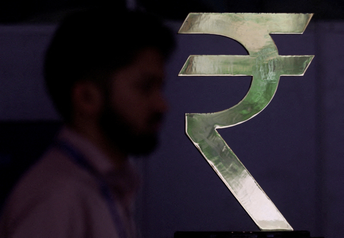FILE PHOTO: A man walks past a Rupee installation at the Reserve Bank Of India (RBI) headquarters in Mumbai, India, April 8, 2026. REUTERS/Francis Mascarenhas/File Photo