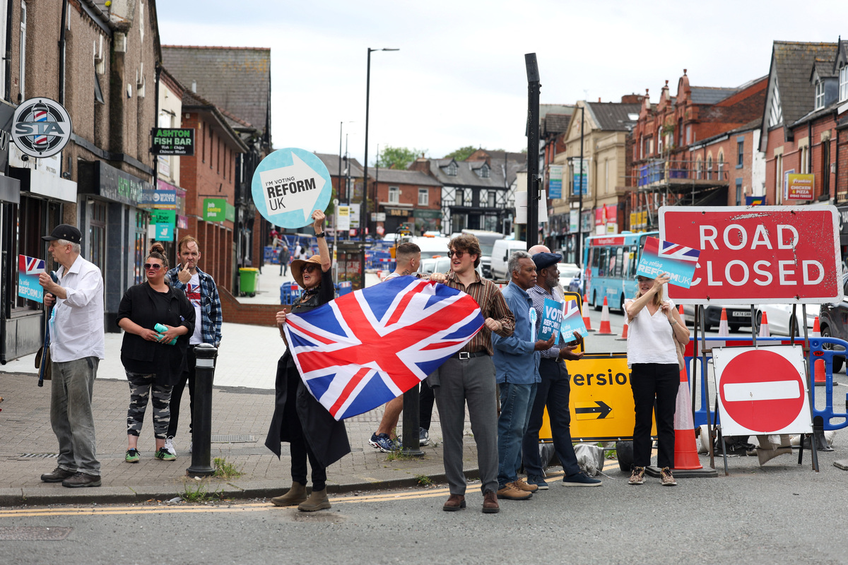 Reform party supporters campaign on a street during the Makerfield by-election, triggered by the resignation of Labour MP John Simons, in Ashton-in-Makerfield, Britain, June 18, 2026. REUTERS/Temilade Adelaja