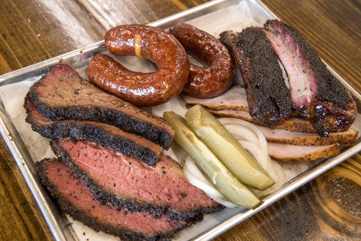  Close-up of a plate of barbecued meats at Mum Foods Smokehouse and Delicatessen in Austin, Texas, on June 16, 2023. Pictured are, clockwise from top center, sausage, pork ribs, smoked turkey, onions, pickles, sliced pastrami, and sliced brisket. (Photo by John Anderson/The Austin Chronicle/Getty Images) 