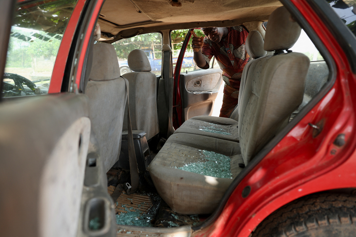 A witness to the abduction of dozens of students and teachers points at shattered glass in his car, damaged by gunfire, in Oyo State, Nigeria, June 2, 2026. REUTERS/Sodiq Adelakun