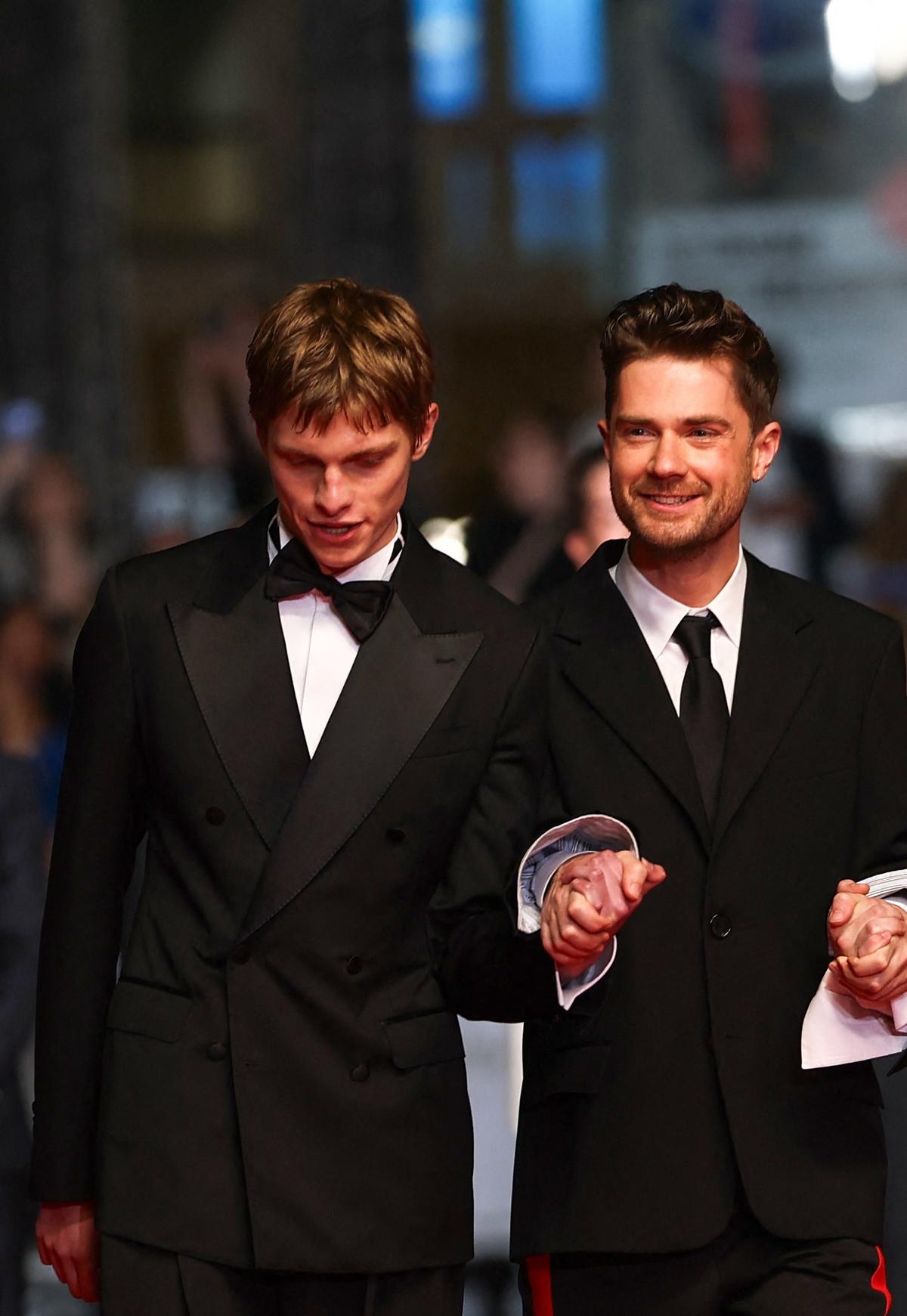 Director Lukas Dhont, cast members Emmanuel Macchia and Valentin Champagne pose on the red carpet during arrivals for the screening of the film "Coward" in competition at the 79th Cannes Film Festival in Cannes, France, May 21, 2026. REUTERS/Gonzalo Fuentes