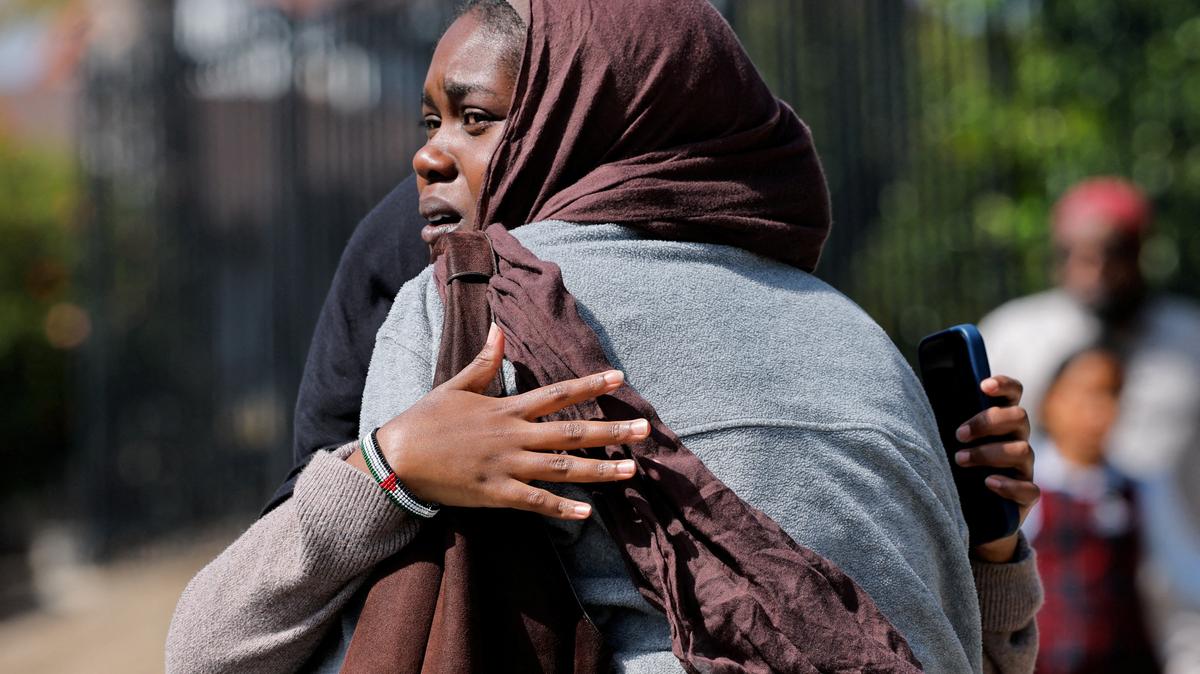 Women hug as they wait for the children to walk out of the mosque, at a collecting area, at the scene of a shooting at the Islamic Center in San Diego, California, U.S., May 18, 2026.  REUTERS/Mike Blake