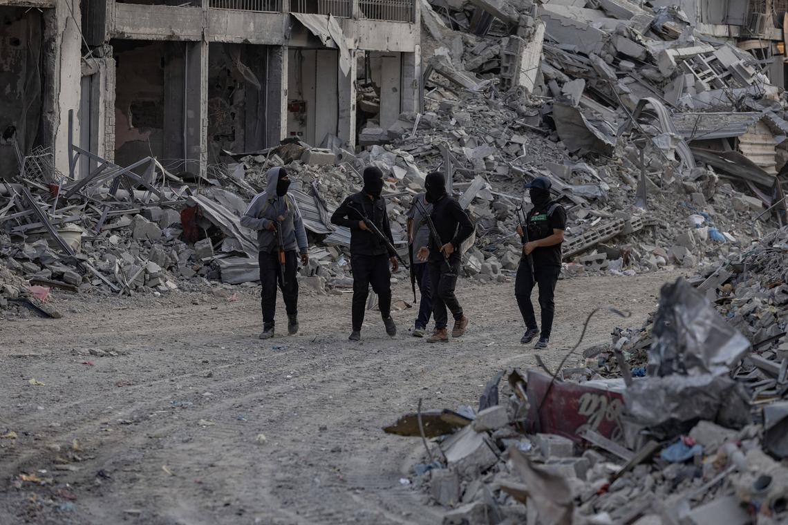 FILE -- Members of the armed wing of Hamas search the Shuja'iyya neighborhood east of Gaza City for the body of an Israeli hostage, Nov. 5, 2025. The Board of Peace has demanded that Hamas give up all of its weapons in exchange for a withdrawal of Israeli troops from Gaza and the reconstruction of parts of the territory destroyed in the war. (Saher Alghorra/The New York Times)