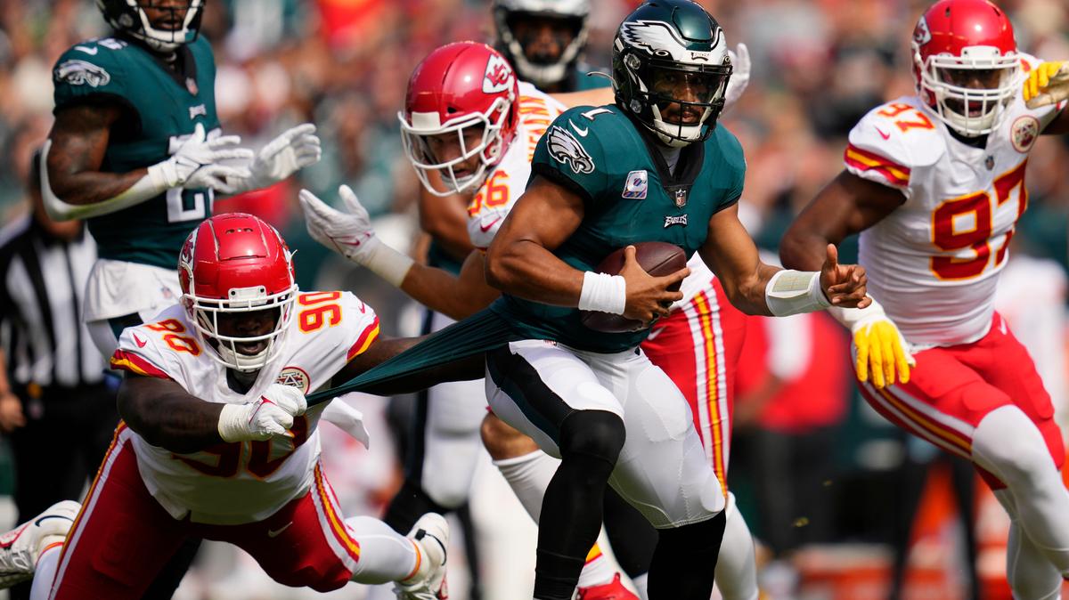 Philadelphia Eagles quarterback Jalen Hurts (1) runs with the ball as Kansas City Chiefs defensive tackle Jarran Reed (90) holds on to part of Hurts’ uniform during the first half of an NFL football game Sunday, Oct. 3, 2021, in Philadelphia. (AP Photo/Matt Slocum)
