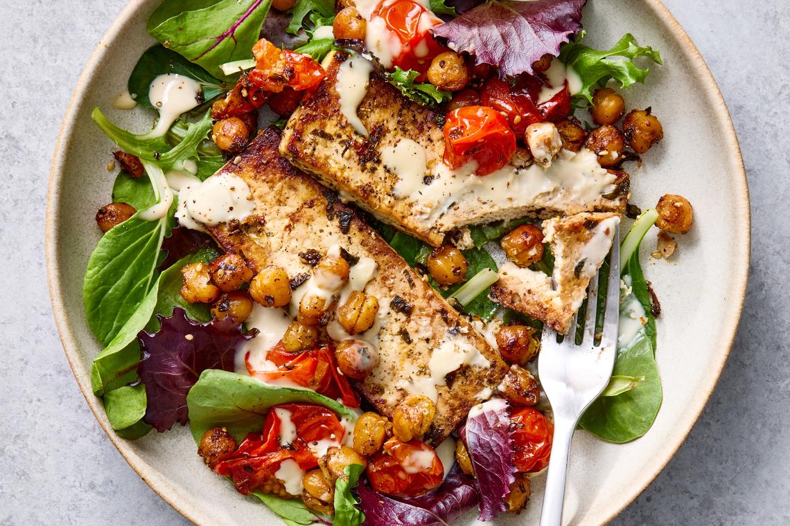 Za'atar roasted tofu with chickpeas, tomatoes and lemony tahini. Yewande Komolafe takes an unusual ingredient pairing -- za'atar and tofu -- and builds a dish that feels both surprising and inevitable. Food styled by Spencer Richards. (Rachel Vanni/The New York Times)
