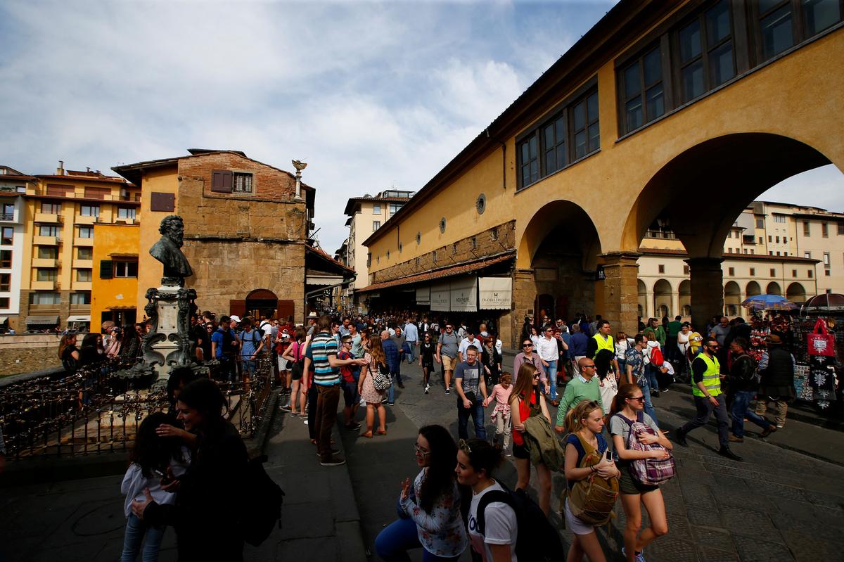 FILE PHOTO: Tourists walk on the Ponte Vecchio (Old Bridge) in Florence, Italy April 1, 2017. REUTERS/Tony Gentile/File Photo