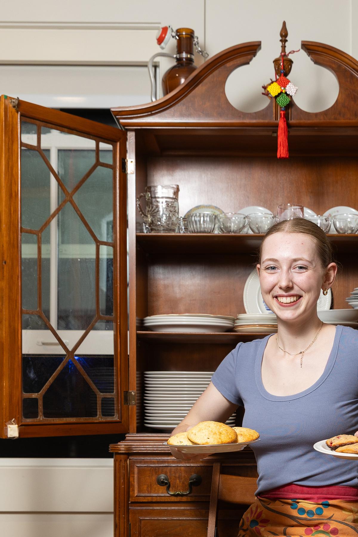 Meghan Howard with plates of scones at the Dacie Moses House, Carleton College's cookie house in Northfield, Minn., March 30, 2026. For decades, Carleton College has kept a place where students and others can come, bake and share. (Liam James Doyle/The New York Times)