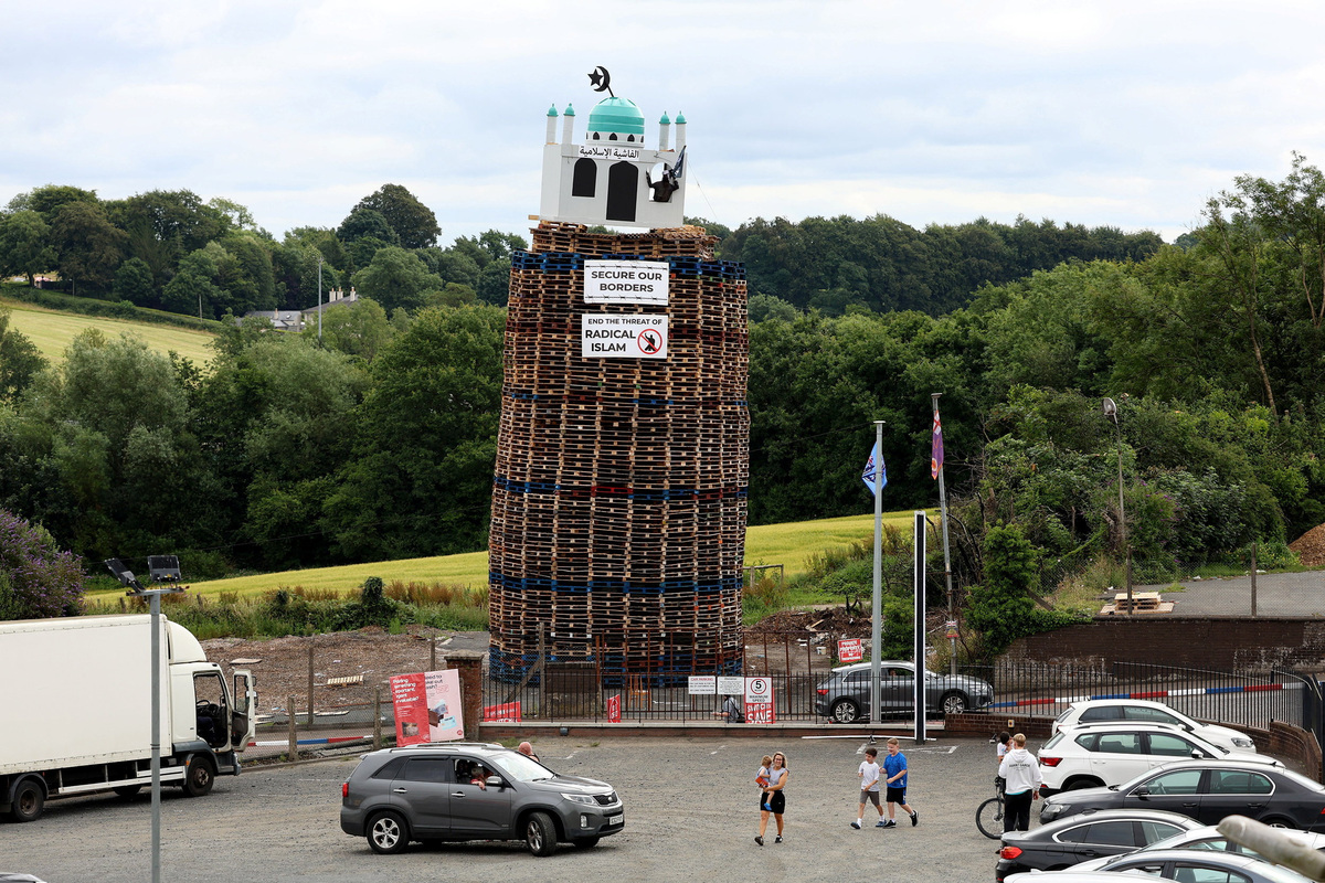 An effigy of a person holding a knife in a mosque stands atop the Moygashel bonfire ahead of its lighting as part of the annual bonfire events marking the 1690 Battle of the Boyne, in Moygashel, Northern Ireland, July 9, 2026. REUTERS/Cathal McNaughton