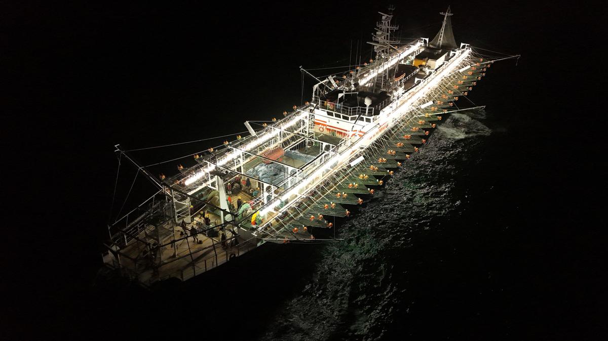 A drone view shows crew members aboard a squid jigger vessel operating outside Argentina's exclusive economic zone, where foreign fishing vessels, mostly Chinese, operate just beyond the boundary, in the South Atlantic Ocean off the coast of Argentina, January 18, 2026. REUTERS/Agustin Marcarian