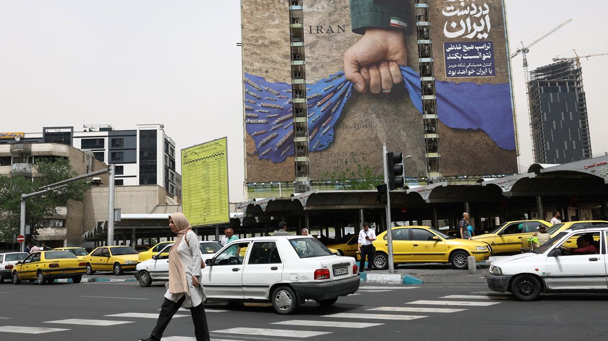 People walk past a billboard with a graphic design about the Strait of Hormuz on a building, in Tehran, Iran, May 4, 2026. Majid Asgaripour/WANA (West Asia News Agency) via REUTERS