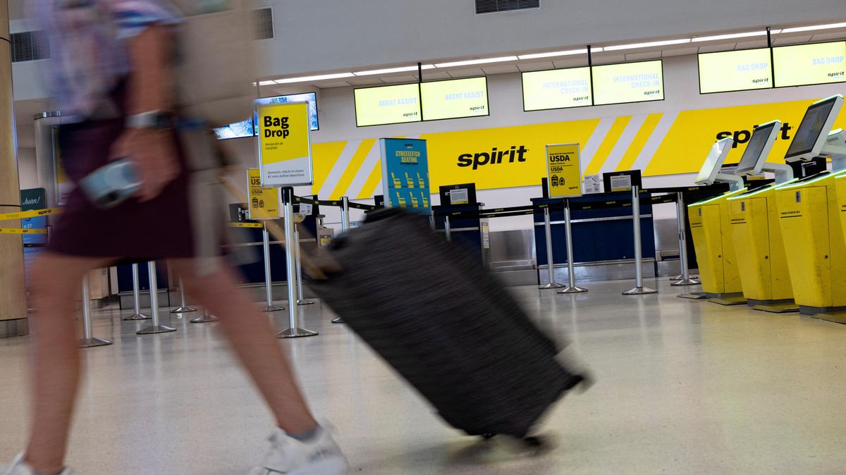 A passenger walks past the Spirit Airlines check-in area at Luis Munoz Marin International Airport after the airline announced it was ceasing operations early Saturday following an impasse in talks with some creditors over a $500 million government bailout plan, in Carolina, Puerto Rico, May 2, 2026. REUTERS/Ricardo Arduengo