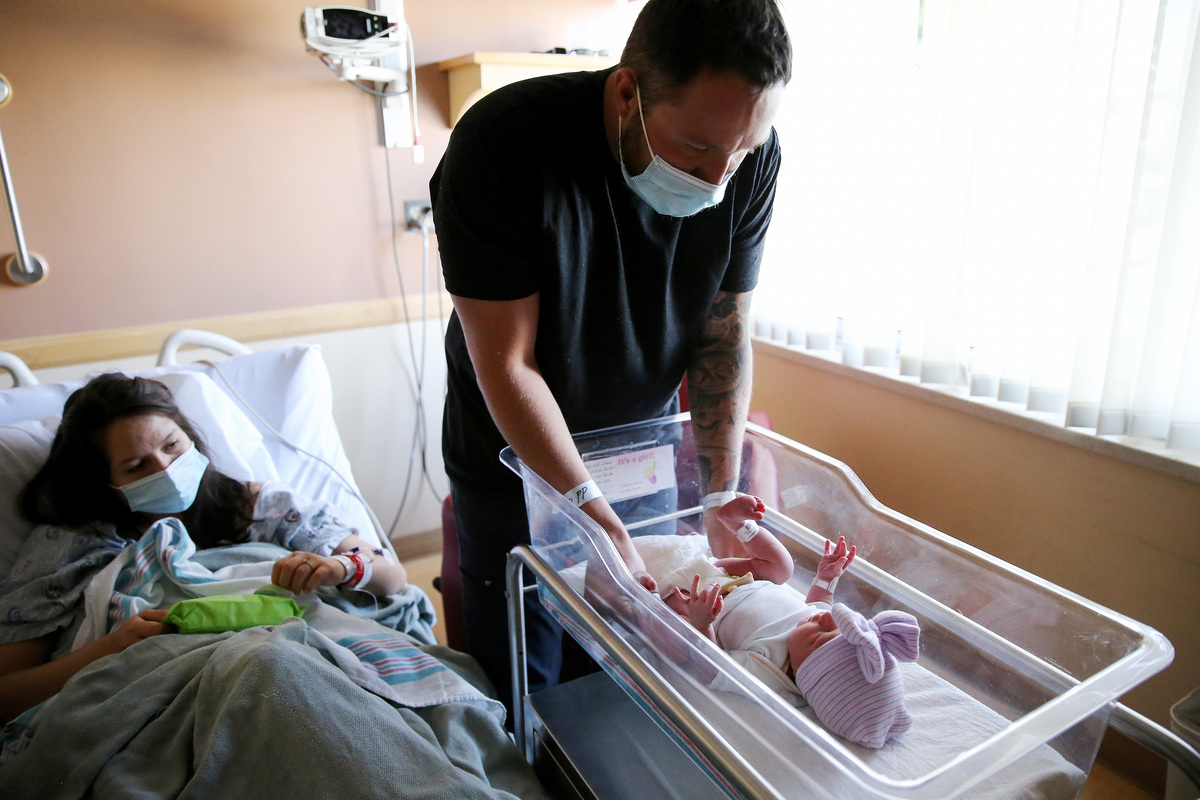  Matthew Carnes prepares to change diapers for his newborn daughter Evelina Carnes as his wife Breanna Llamas keeps watch in the postpartum unit at Providence St. Mary Medical Center on March 30, 2021, in Apple Valley, California. (Photo by Mario Tama/Getty Images) 