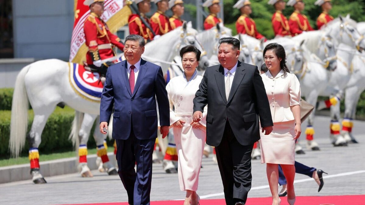 North Korean leader Kim Jong Un (2-R) and his wife, Ri Sol-ju (R), walk with Chinese President Xi Jinping (L) and his wife, Peng Liyuan (2-L) during a welcome ceremony for the Chinese leader at Kim Il Sung Square in Pyongyang on Thursday. Photo by KCNA/EPA