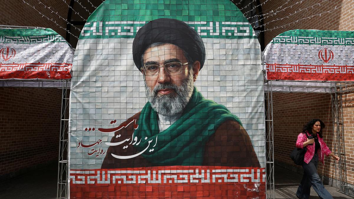 A woman walks next to a banner with a picture of Iran's new Supreme Leader Mojtaba Khamenei in Tehran, Iran, May 8, 2026. Majid Asgaripour/WANA (West Asia News Agency) via REUTERS