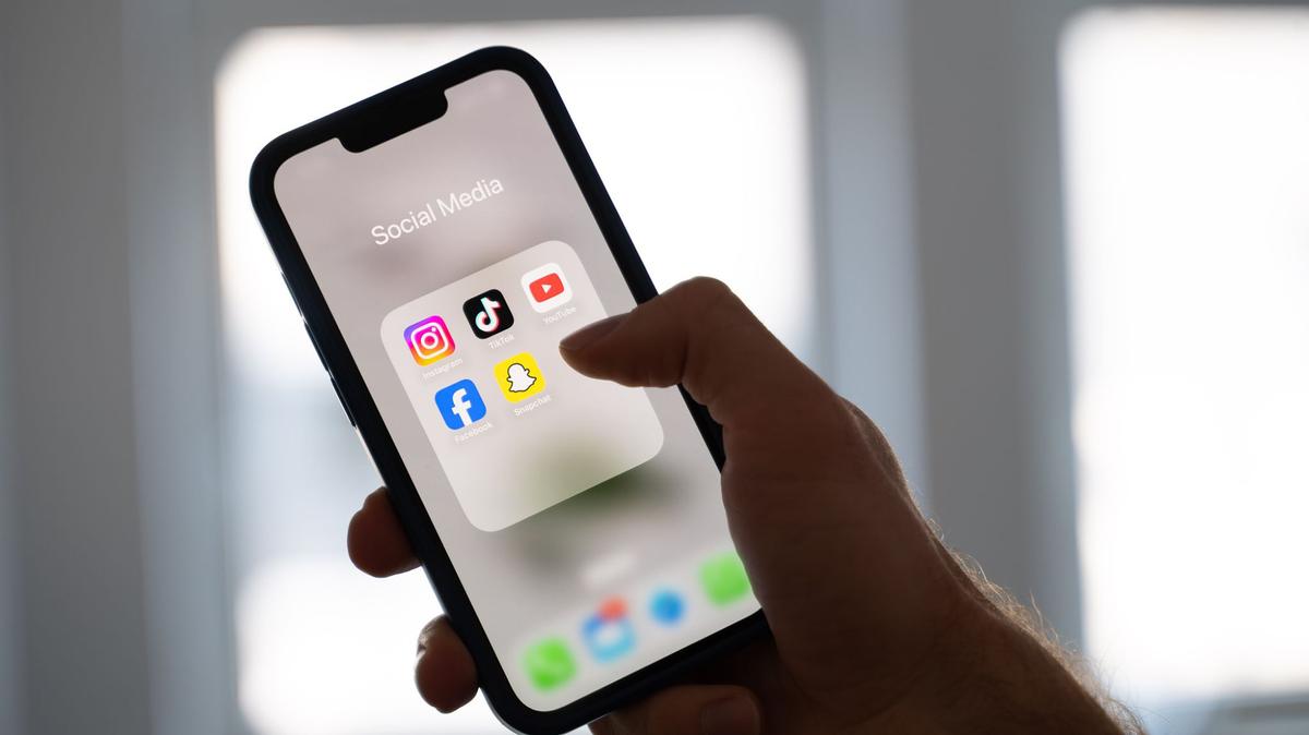 A woman holds a smartphone with various social media apps on the display. A large majority of Germans would support a law similar to what parliament passed on 29 November in Australia, restricting access to social media to those older than 16, a survey published on Nov. 30, 2025, showed. (Alicia Windzio/PA Media/dpa/TNS)