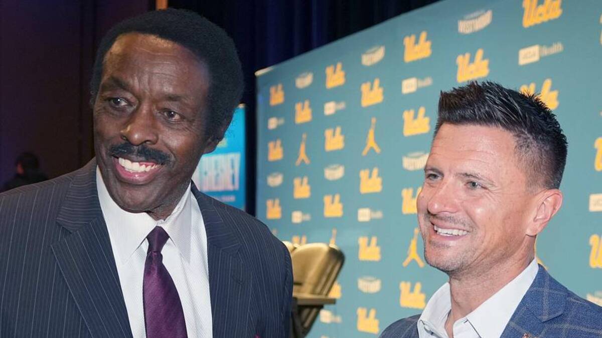  Dec 9, 2025; Los Angeles, CA, USA; UCLA Bruins football coach Bob Chesney (right) with CBS Los Angeles sports director Jim Hill at introductory press conference at Renee Luskin Conference Center Centennial Ballroom. Mandatory Credit: Kirby Lee-Imagn Images | Kirby Lee-Imagn Images 