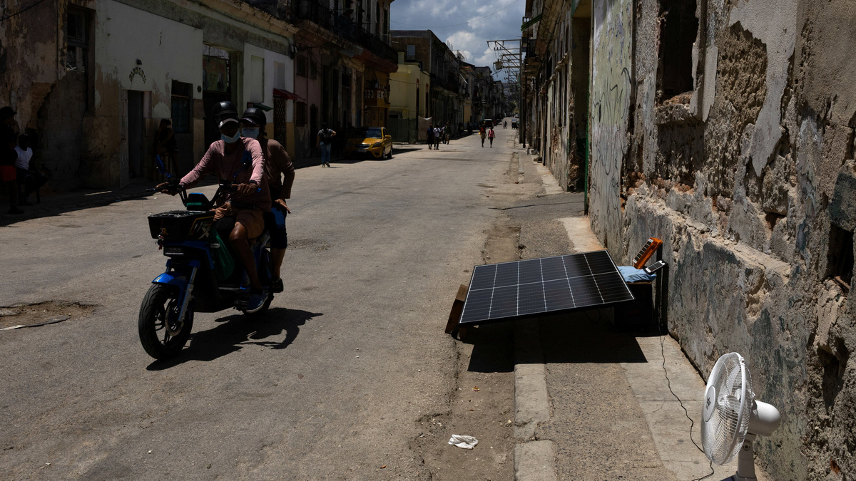 A person rides an electric motorcycle past a solar panel on a street as Cuba's national electric grid collapsed at midday, leaving around 10 million people without power, in Havana, Cuba July 6, 2026. REUTERS/Norlys Perez