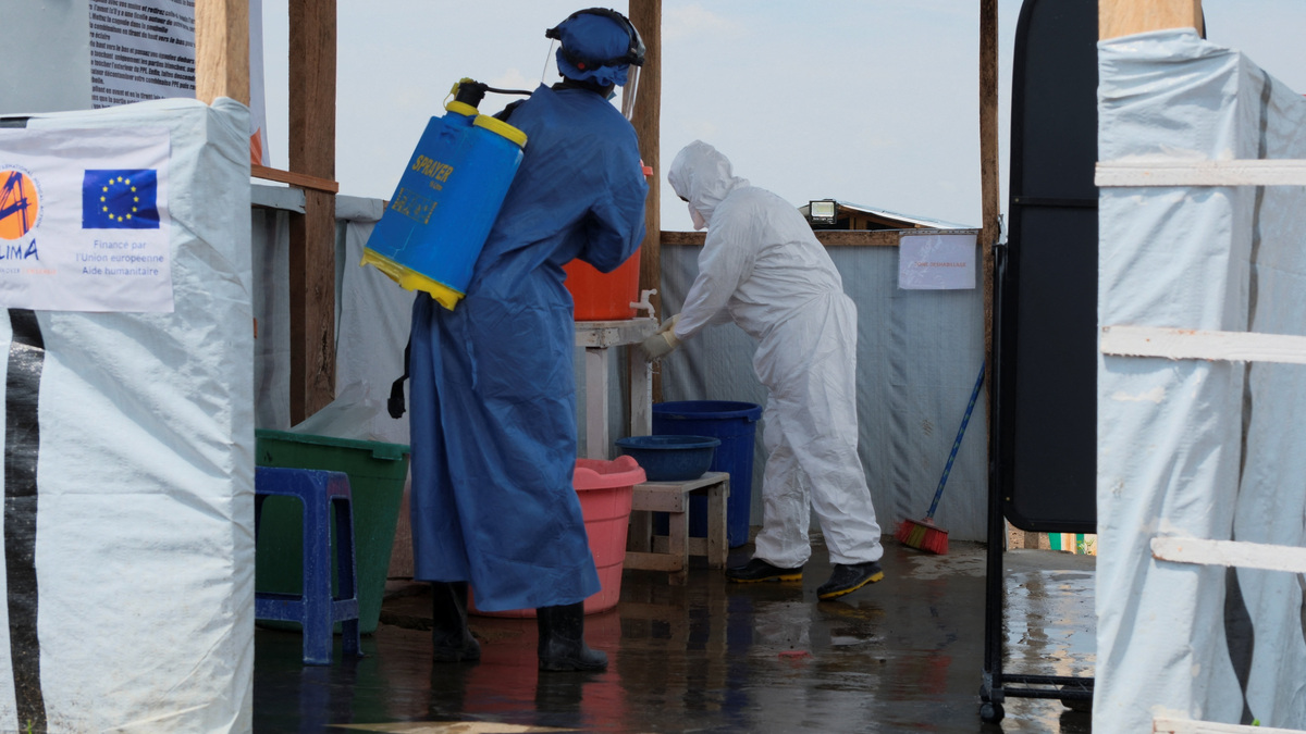 Medical workers dressed in personal protective equipment (PPE) disinfect and wash their hands at an Ebola treatment centre during a ceremony to present recovery certificates to patients at the Rwambara General Reference Hospital in Bunia, eastern Democratic Republic of Congo, June 16, 2026. REUTERS/Gradel Muyisa Mumbere