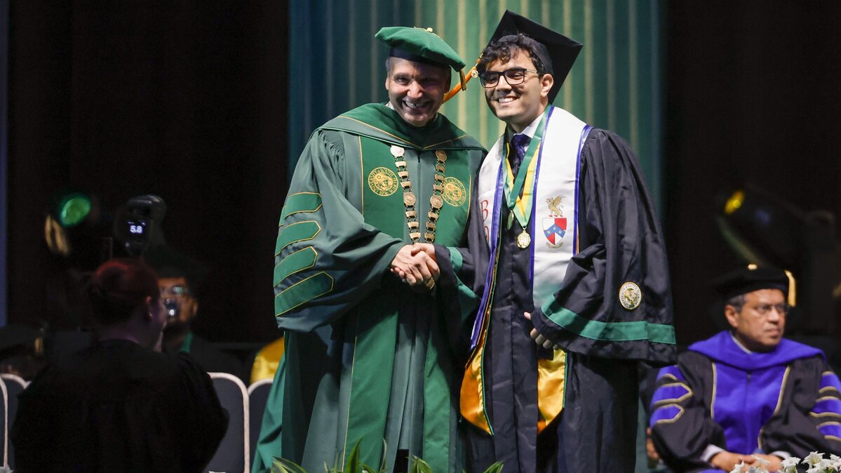 Arshia Esmaeilian poses for a photo with University of South Florida President Moez Limayem during a commencement ceremony on May 9 in Tampa, Florida. (Luis Santana/Tampa Bay Times/TNS)